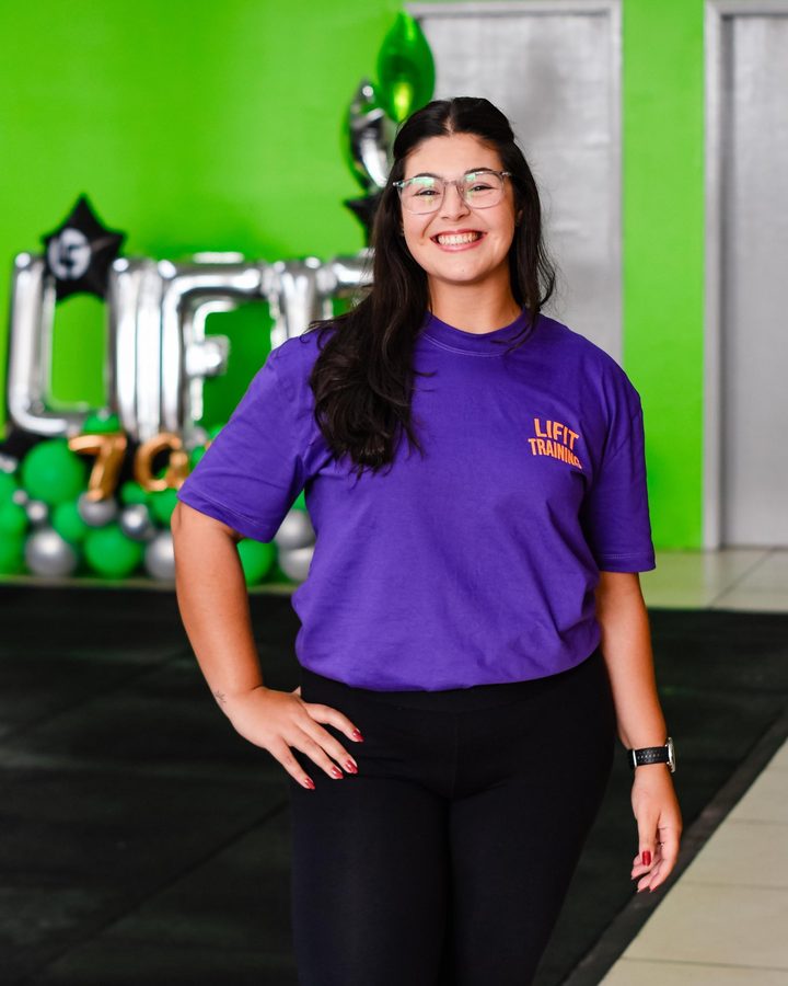 Coach Gi sorrindo no box, com a camiseta roxa da Lifit Training